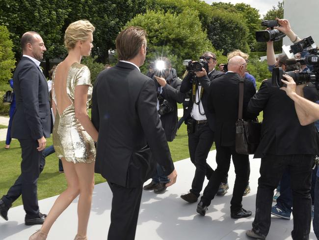 Super sexy ... Charlize Theron and companion Sean Penn making a stunning entrance at the Dior show in Paris.