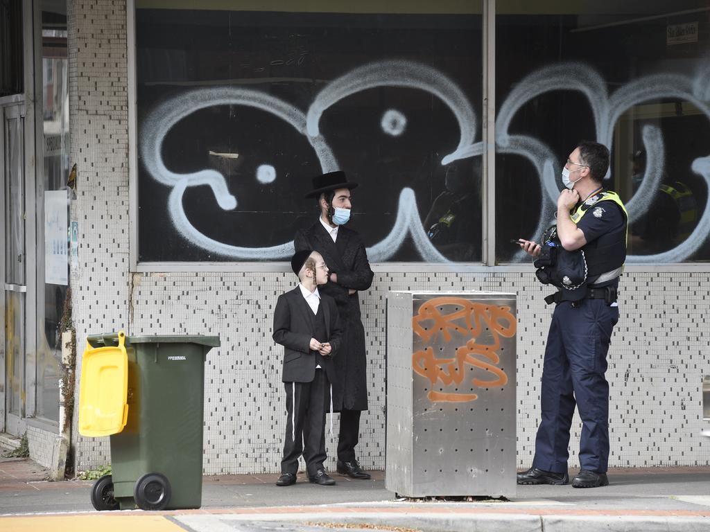 Police speak to locals near an alleged illegal gathering at a synagogue in Ripponlea. Picture: Andrew Henshaw