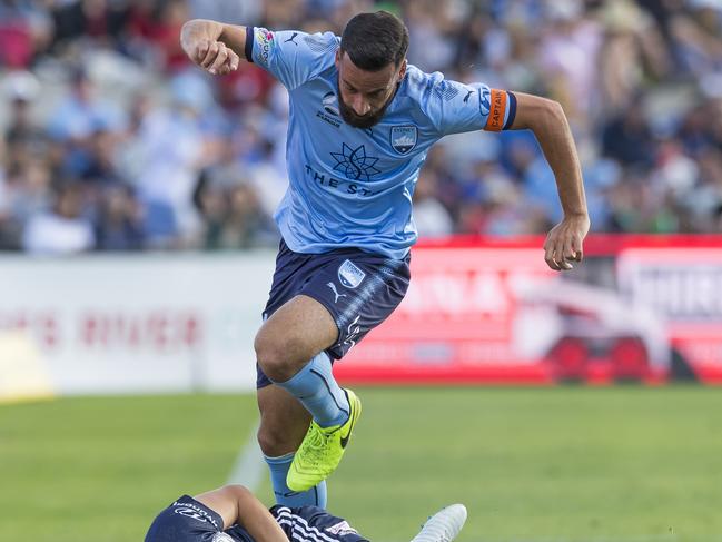 Alex Brosque hurdles Georg Niedermeier of the Victory earlier this season. Picture: Craig Golding