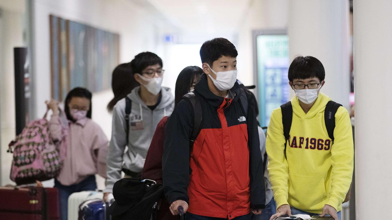 People arriving and wearing mask at the airport. International Airport, Brisbane, 4th of March 2020. Picture: AAP Image/Attila Csaszar