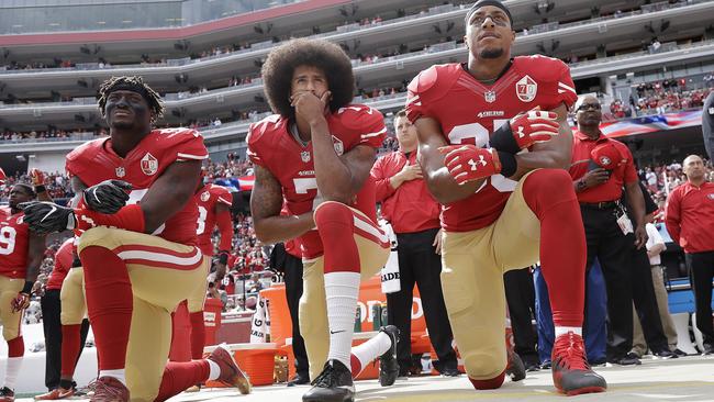 San Francisco 49ers outside linebacker Eli Harold, left, quarterback Colin Kaepernick, centre, and safety Eric Reid kneel during the national anthem before an NFL game last October.