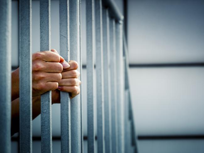 Generic photo of hands in jail cell.