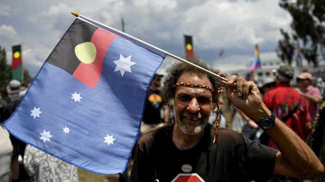 AUSTRALIA DAY DEBATE: A man hold a flag where the Aboriginal flag replaces the Union Jack during a protest on Australia Day, Friday, January 26, 2018. Picture: MICK TSIKAS