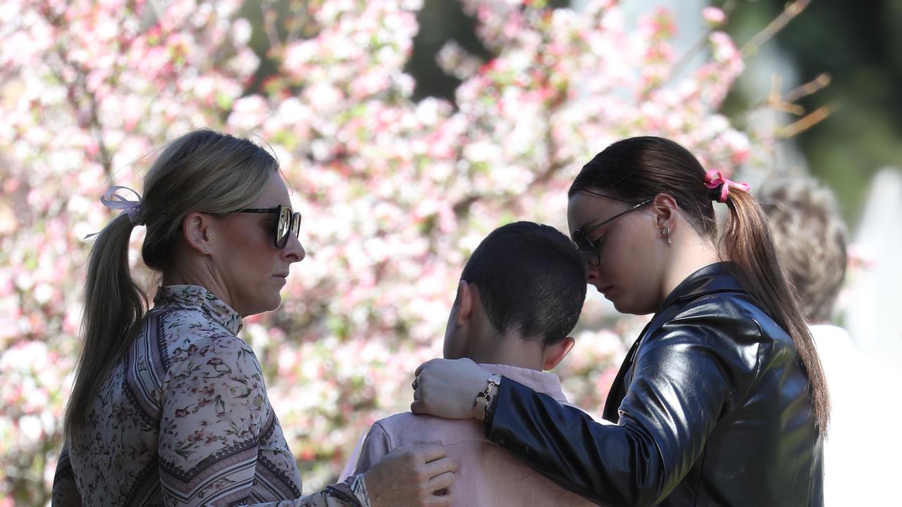 Loved ones embraced at the teens funeral. Picture: John Grainger