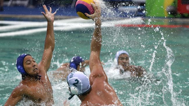 Australia's Richie Campbell, right, passes the ball forward in the match against Japan on Wednesday. The pool around them was turning green. Picture: AP Photo/Sergei Grits
