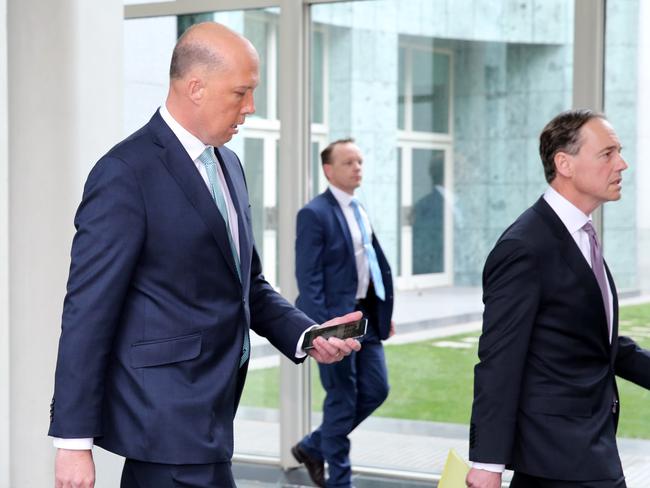 Peter Dutton checks his phone as he follows Greg Hunt into the Reps Chamber. Picture: Ray Strange