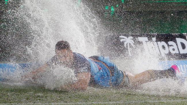 GOLD COAST, AUSTRALIA — JULY 15: Jarryd Hayne of the Titans hits a puddle of water during the round 19 NRL match between the Gold Coast Titans and the Cronulla Sharks at Cbus Super Stadium on July 15, 2017 in Gold Coast, Australia. (Photo by Jason O'Brien/Getty Images)