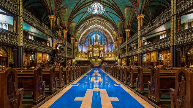 Interior of Notre-Dame cathedral viewed towards its altar, in Montreal, Canada. The church's Gothic Revival architecture is among the most spectacular in the world.