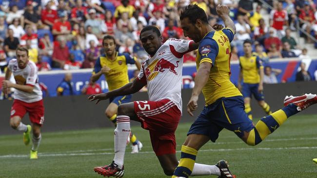 Santi Cazorla #19 of Arsenal fights for the ball with Chris Duvall #25 of New York Red Bulls.