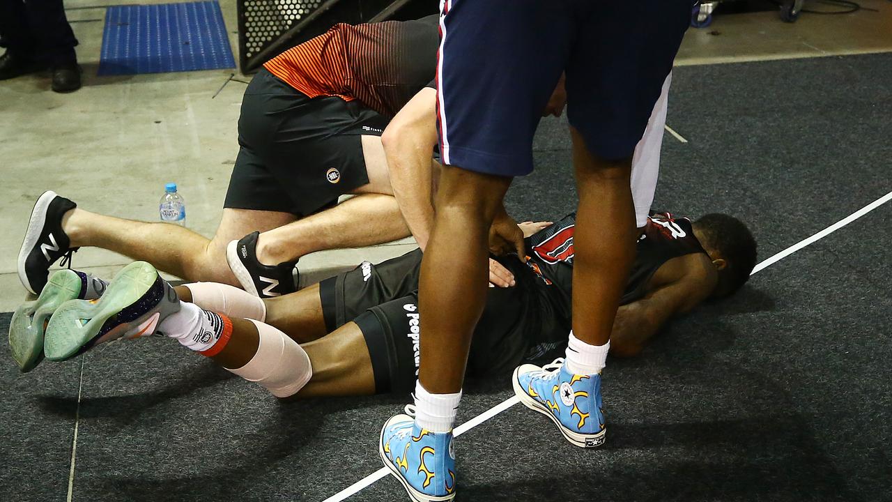 Aaron Brooks of the Hawks receives attention for an injury.