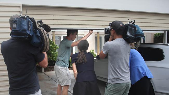 Rohan Dennis enters his property as media ask him questions.