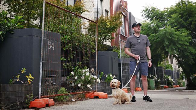 Dylan Forrest and his dog Blue pictured on Metters St, Erskineville in front of homes that sit vacant while many renters struggle to find housing. Picture: Sam Ruttyn