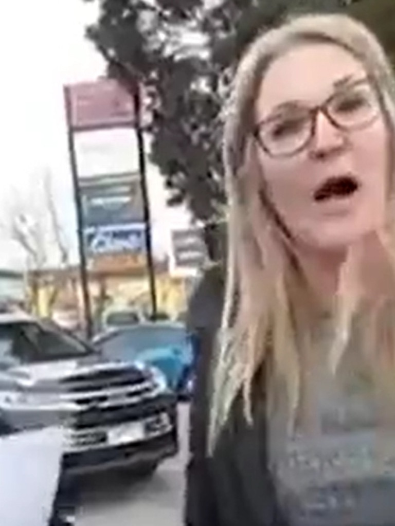 A woman argues with police outside a Bunnings about her rights not to wear a mask.