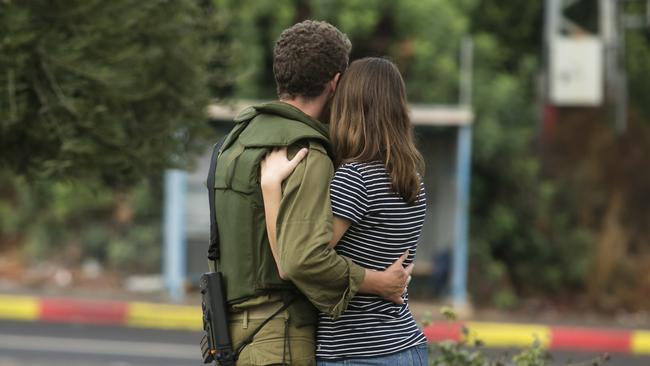 RAMOT NAFTALI, ISRAEL - OCTOBER 15: An Israeli soldier hugs a woman near the border with Lebanon on October 15, 2023 in Ramot Naftali, Israel. Israel has sealed off Gaza and launched sustained retaliatory air strikes, which have killed at least 1,400 people with more than 400,000 displaced, after large-scale attack by Hamas. On October 7, the Palestinian militant group Hamas launched a surprise attack on Israel from Gaza by land, sea, and air, killing over 1,300 people and wounding around 2,800. Israeli soldiers and civilians have also been taken hostage by Hamas and moved into Gaza. The attack prompted a declaration of war by Israeli Prime Minister Benjamin Netanyahu and the announcement of an emergency wartime government. (Photo by Amir Levy/Getty Images)