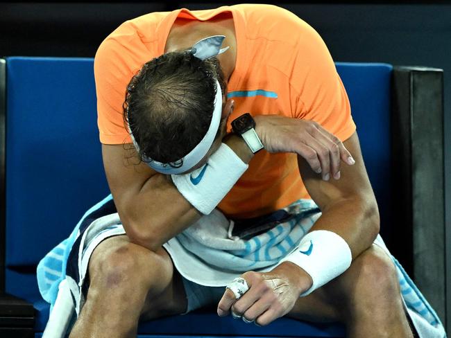 TOPSHOT - Spain's Rafael Nadal takes rest during the break in his men's singles match against Mackenzie McDonald of the US on day three of the Australian Open tennis tournament in Melbourne on January 18, 2023. (Photo by MANAN VATSYAYANA / AFP) / -- IMAGE RESTRICTED TO EDITORIAL USE - STRICTLY NO COMMERCIAL USE --