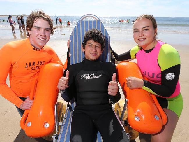 Jan Juc Surf Lifesaving Club volunteers Samuel Dripps and Lulu Higgins with Tjay Curtis at Torquay  about to hit the waves for Kids Plus Foundation Surf Ed Program.Picture: Peter Ristevski