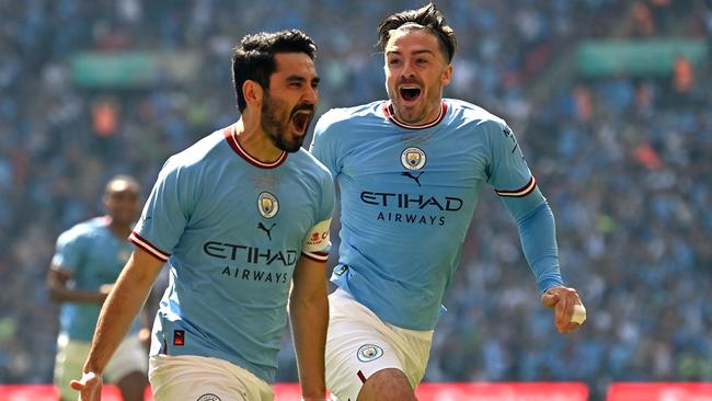 Manchester City's German midfielder Ilkay Gundogan celebrates with Manchester City's English midfielder Jack Grealish (R) after scoring the early opening goal during the English FA Cup final football match between Manchester City and Manchester United at Wembley stadium, in London, on June 3, 2023. (Photo by Glyn KIRK / AFP)