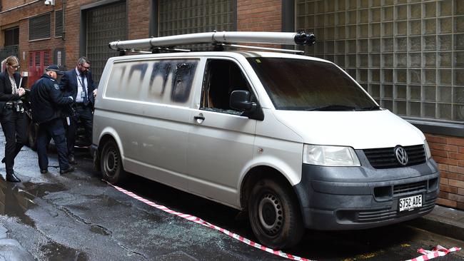 Police inspect a van set on fire and robbed of tools on Featherstone Pl in the CBD. Picture: Naomi Jellicoe