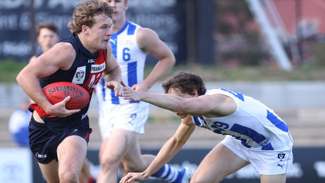 VFL: Coburg’s Max Thompson burns off a North Melbourne tackler. Picture: Hamish Blair