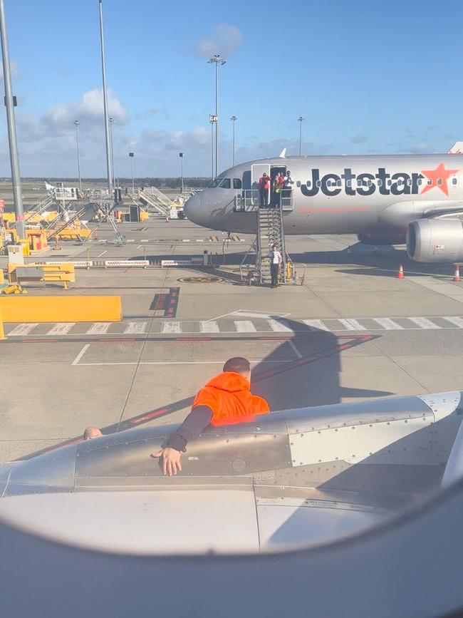 A passenger has opened the emergency exit of a plane before going down the emergency slide. Picture: James Gordon/X.