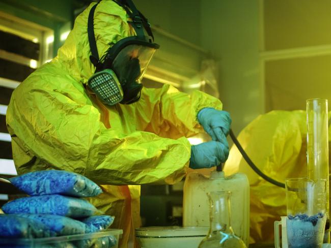 Meth lab generic 2020: In the Underground Drug Laboratory Two Clandestine Chemists Wearing Protective Masks and Coveralls Use Hosepipe For Drug Distillation. They Cook Synthesised Drugs in the Abandoned Building. iStock.