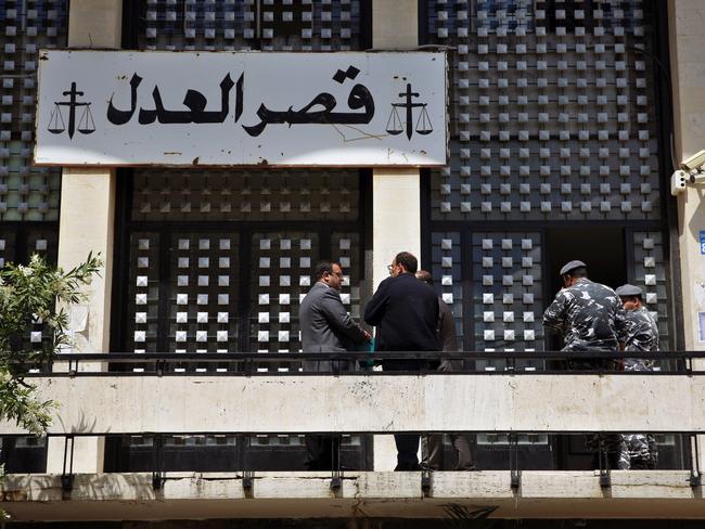 Civilians and policemen stand near the entrance of a courthouse where the 60 Minutes crew were detained. Picture: AP