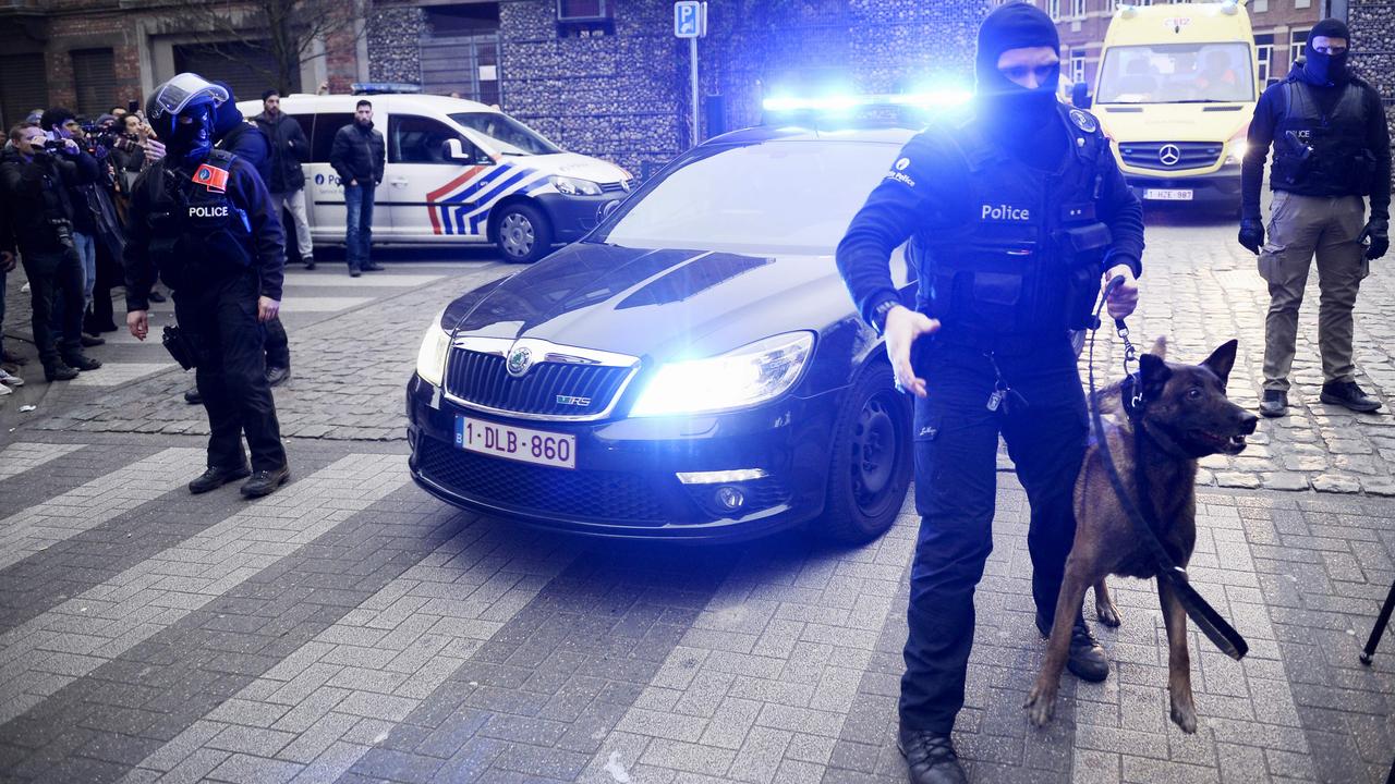 Policemen block a road, near the scene of a police raid in the Molenbeek-Saint-Jean district in Brussels, on March 18, 2016, as part of the investigation into the Paris November attacks. The main suspect in the jihadist attacks on Paris in November, Salah Abdeslam, was arrested in a raid in Brussels on March 18, French police sources said. / AFP PHOTO / BELGA / DIRK WAEM / Belgium OUT