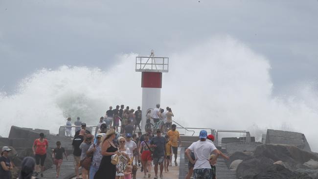 Tourists and locals watch on as giant surf pounds the Gold Coast Seaway. Picture Glenn Hampson