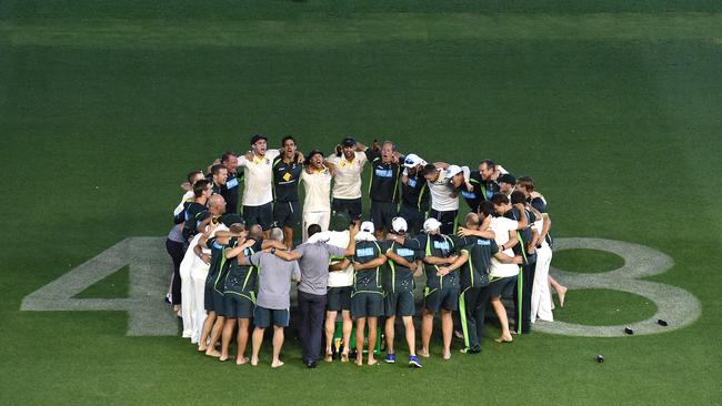 The Australian team gather around the number 408, in memory of Phillip Hughes, on the Adelaide Oval outfield to celebrate their victory against India.