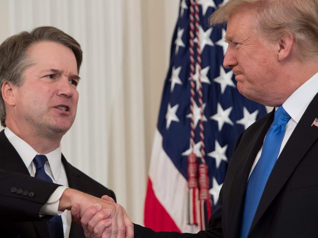 US Judge Brett Kavanaugh (L) shakes hands with US President Donald Trump after being nominated to the Supreme Court in the East Room of the White House on July 9, 2018 in Washington, DC.  / AFP PHOTO / SAUL LOEB