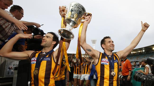 Former Hawthorn stars Jordan Lewis and captain Luke Hodge carry the premiership trophy into the race after beating West Coast in the 2015 grand final. Picture: David Caird.