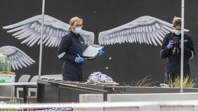 Bullet holes seen at a Keilor cafe as homicide and forensic police search the crime scene. Picture: Tony Gough