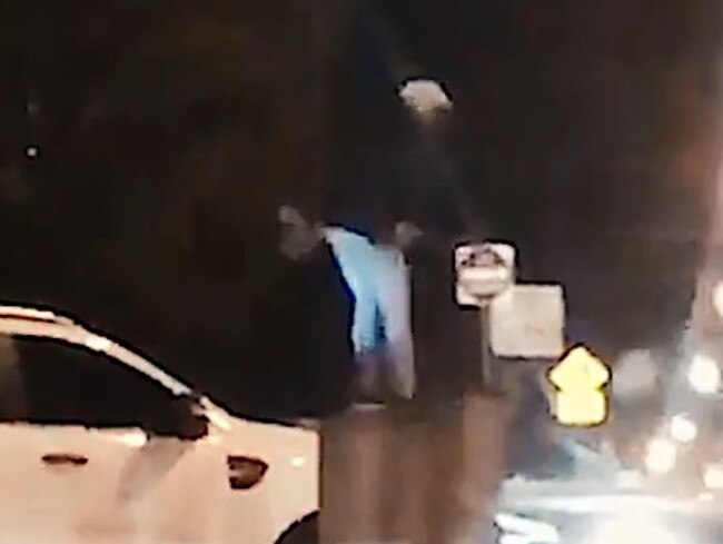 The footage shows the man on the bonnet of the car.