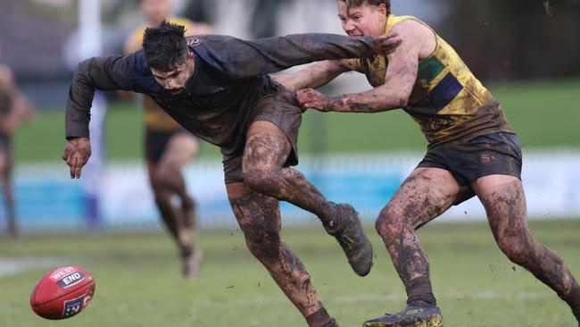 Mud-splattered Panther Eamon Wilkinson chases down the loose ball under pressure from Eagle Max Litster at Woodville Oval on Sunday. Picture: Cory Sutton/SANFL.