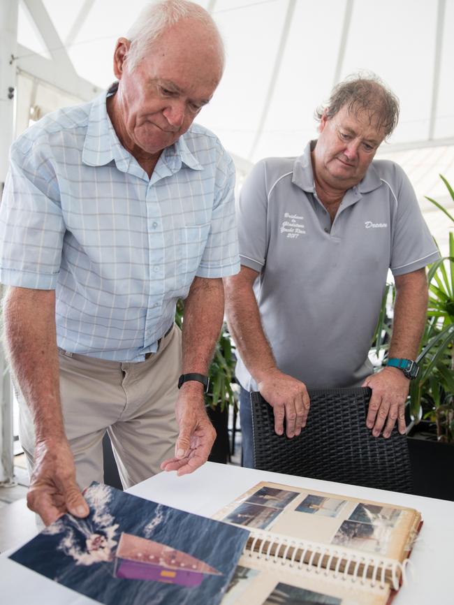 Ian Gleeson and Craig Salter look over old photos of the yacht Dream which will contest the 70th anniversary Brisbane to Gladstone Yacht Race.