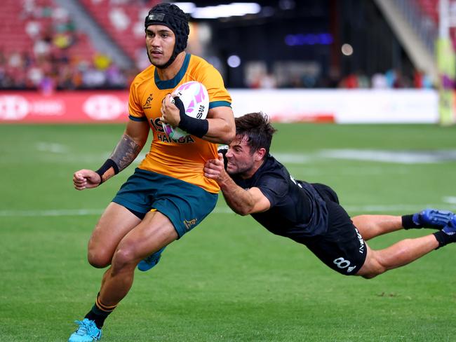 SINGAPORE, SINGAPORE - MAY 05: Dietrich Roache #4 of Australia runs with the ball for a try against Andrew Knewstubb #8 of New Zealand in the men's cup semifinal match during day three of the HSBC SVNS Singapore at the National Stadium on May 05, 2024 in Singapore. (Photo by Yong Teck Lim/Getty Images)