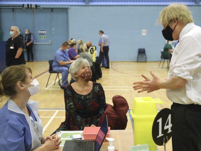 Boris Johnson speaks with a woman about to receive the AstaZeneca vaccine. Picture: AFP