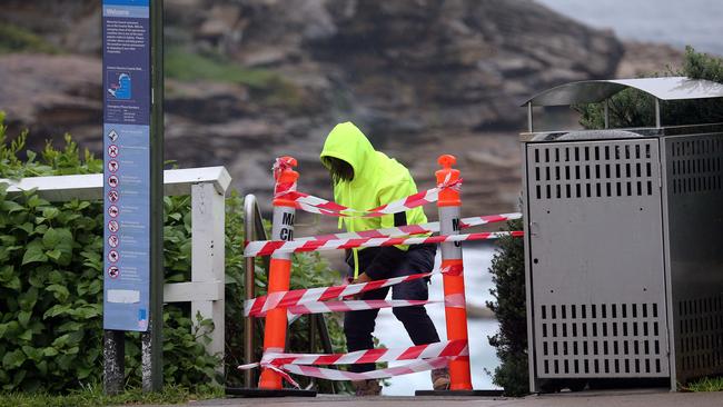 A council worker tapes off the Bondi to Bronte coastal walk. Picture: Matrix.