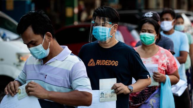 People wearing face masks and shields queue as they wait to be tested for the coronavirus at a seafood market in Samut Sakhon, Thailand, on December 19. Picture: AFP