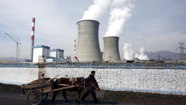 DATONG COUNTY, CHINA - JANUARY 31: (CHINA OUT) A farmer leads a cart walking past cooling towers of the coal-fired Datong County Thermal Power Plant on January 31, 2007 in Datong County of Qinghai Province, China. China has failed to make any headway with its efforts to protect the environment over the last three years as compared with other nations. A new government report ranks the country 100th on a list of 118 developing and developed countries in terms of "ecological modernization", the same ranking it held in 2004, according to the Modernization Report 2007 released by the Chinese Academy of Science. (Photo by China Photos/Getty Images)