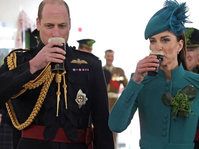 Britain's Prince William, Prince of Wales (L) and Britain's Catherine, Princess of Wales enjoy a drink of Guinness with members of the 1st Battalion Irish Guards, following their St Patrick's Day Parade at Mons Barracks in Aldershot, south west of London, on March 17, 2023. (Photo by Chris Jackson / POOL / AFP)