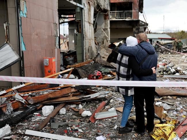 People hug as they look on at the destruction caused when a civilian building was hit by a Russian missile in Lviv, Ukraine. Picture: Getty Images