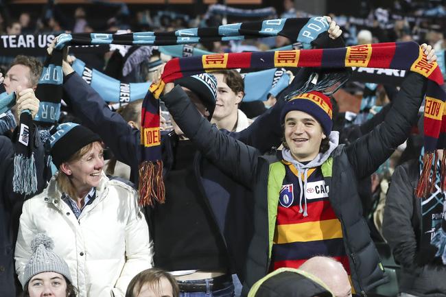 A lone Crows fan stands between the Power supporters during the pre-game for “Never Tear Us Apart” countdown at Adelaide Oval. Picture Sarah Reed