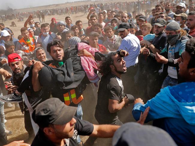 Palestinians carry a demonstrator injured during clashes with Israeli forces over the US embassy move to Jerusalem on May 14. Picture: AFP