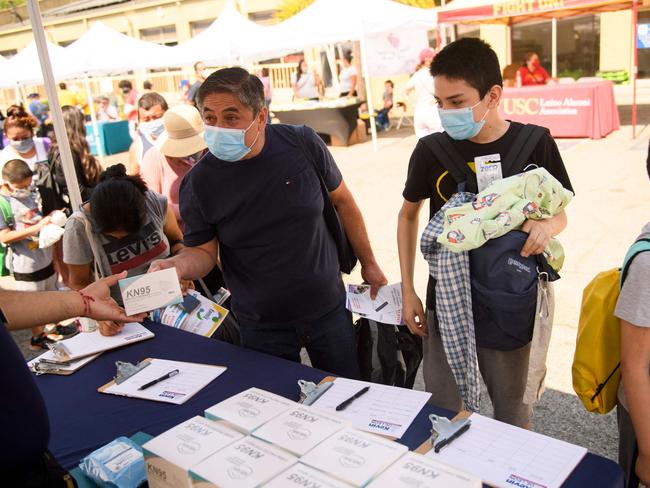 Students receive boxes of face masks during a back to school event offering school supplies, Covid-19 vaccinations and other resources for children in Los Angeles. Picture: AFP