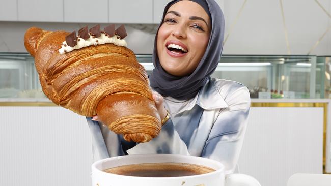 Naaila Dalati with the giant croissant that takes three days to make. New Greenacre cafe La Doree adds a six-litre coffee and charges $110. Picture: Jonathan Ng