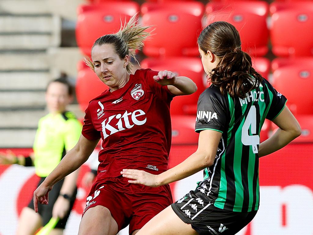 Dylan Holmes of Adelaide United and Claudia Mihocic of Western United battle for the ball. Photo: Sarah Reed/Getty Images.