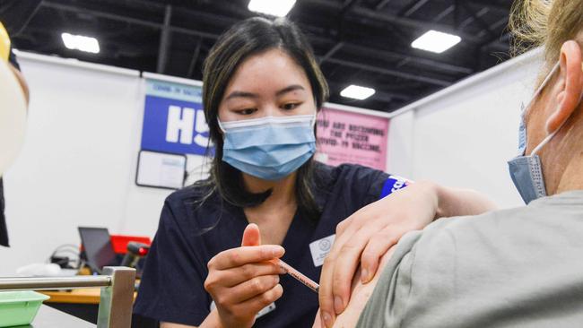 SA Health vaccinator Xuan gives paramedic Sharon a Covid booster vaccine at Wayville Vaccination Clinic. Picture: NCA NewsWire/Brenton Edwards