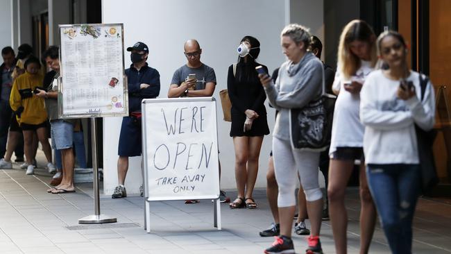 People queue outside a Woolworths store in Sydney’s Mascot on Friday. Picture: Nikki Short