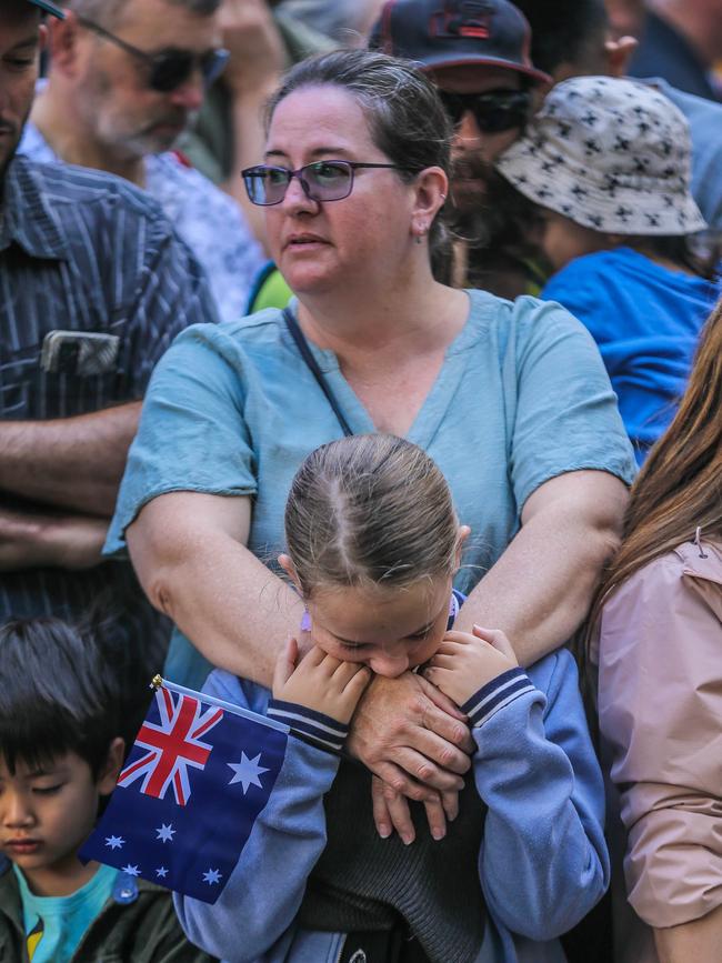 Bailee Boyd, 9, during a minute’s silence with mum Joie in Brisbane for the 2023 ANZAC Day March. Picture: NCA NewsWire / Glenn Campbell